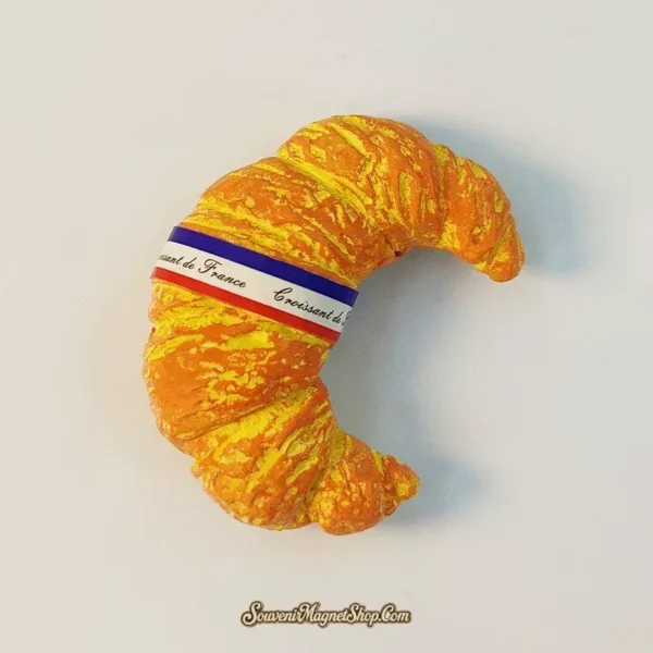 Angled France croissant souvenir magnet showing hand-painted flaky pastry layers