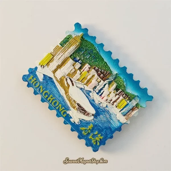 Angled view of Hong Kong skyline souvenir magnet showing hand-painted 3D relief and stamp edge