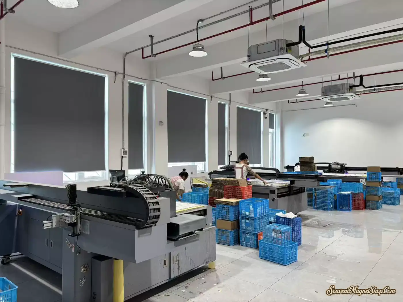 Overview of our plate-making workshop — multiple laser-cutting stations, organized inventory, and continuous batch production for our 80+ country catalog.