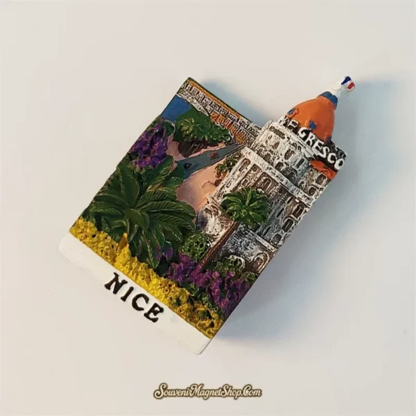 Angled view of hand-painted Nice Negresco souvenir fridge magnet showing 3D Riviera relief detail