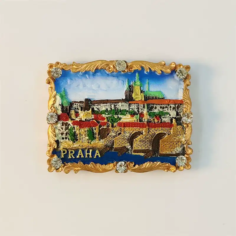 Prague Charles Bridge fridge magnet front view with Prague Castle skyline, red rooftops and ornate gold baroque rhinestone frame