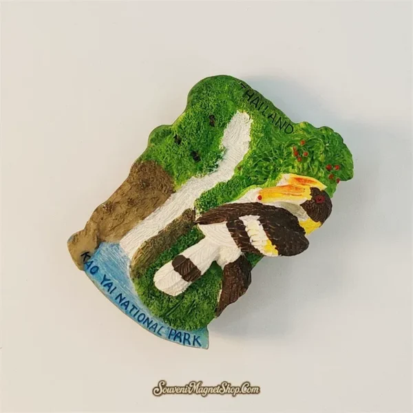 Angled view of Khao Yai souvenir magnet revealing 3D depth of hornbill, cascading waterfall and lush rainforest scenery