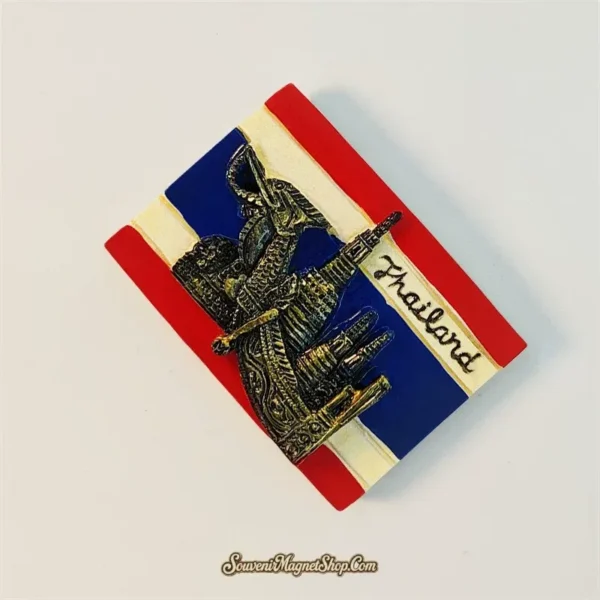 Angled view of Thailand flag souvenir magnet showing dimensional bronze elephant, temple and barge details