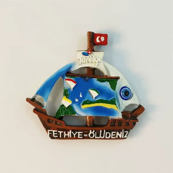 Front view of Fethiye-Ölüdeniz sailing ship fridge magnet with Türkiye flag and blue evil eye