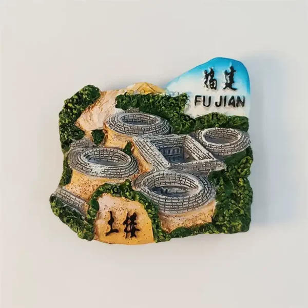 Front view of China Fujian Tulou fridge magnet with 3D grey Hakka roundhouses, green hills and FU JIAN banner