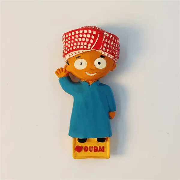 Dubai fridge magnet of cute cartoon Emirati boy in blue robe and red cap waving, front view
