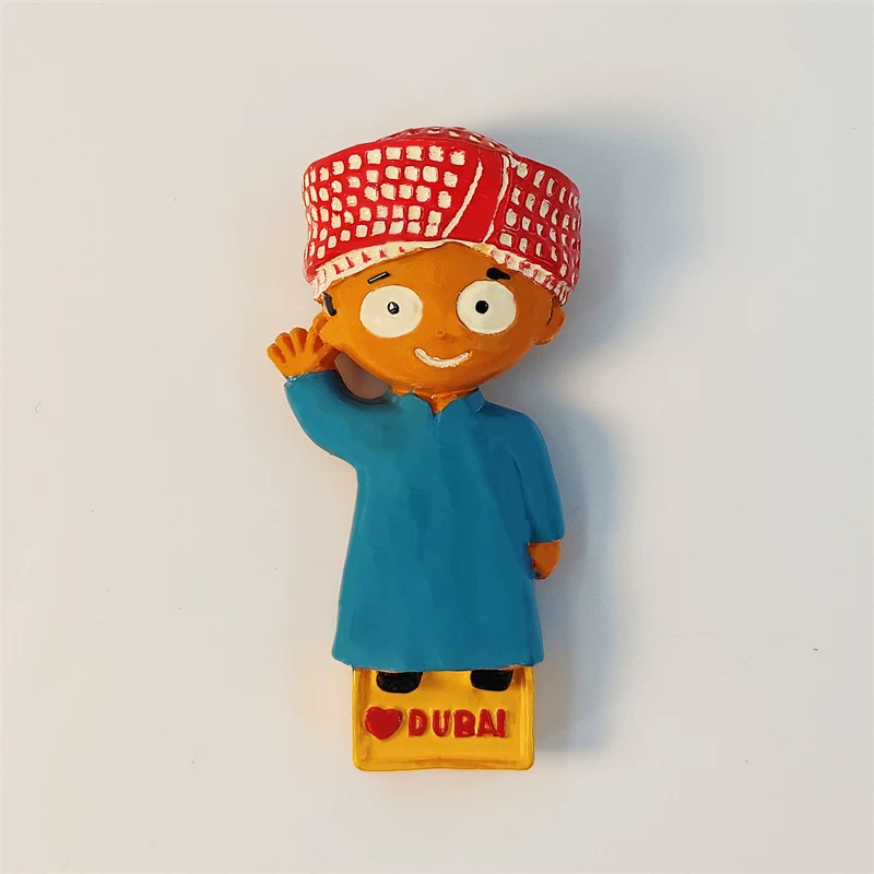Dubai fridge magnet of cute cartoon Emirati boy in blue robe and red cap waving, front view