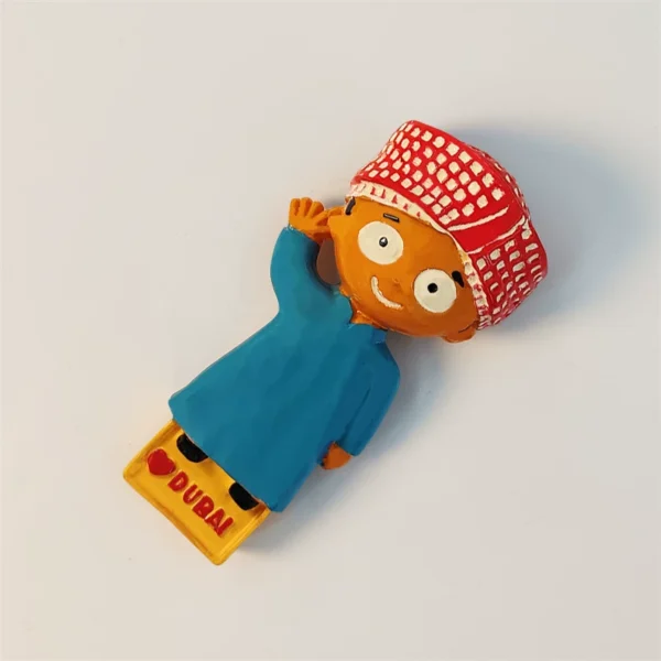 Dubai souvenir magnet of smiling cartoon Emirati boy in teal robe shown at an angle, 3D hand-painted detail