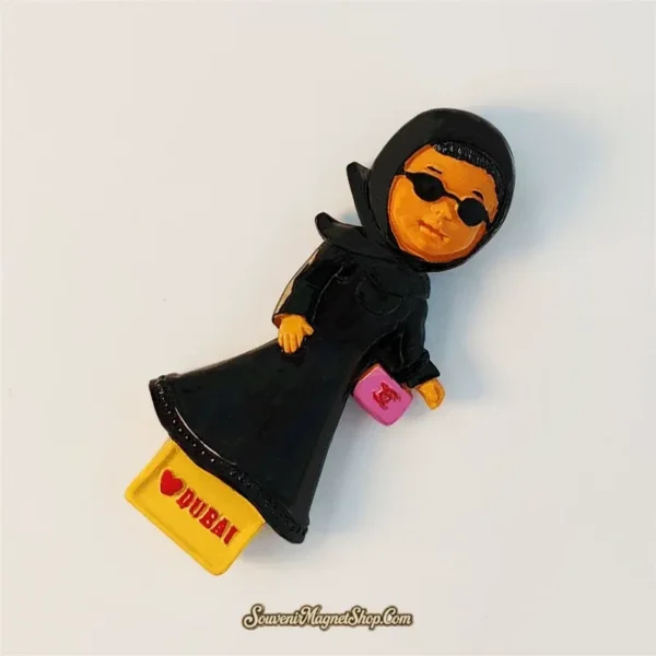 Angled view of hand-painted Dubai Emirati lady souvenir fridge magnet in abaya and sunglasses