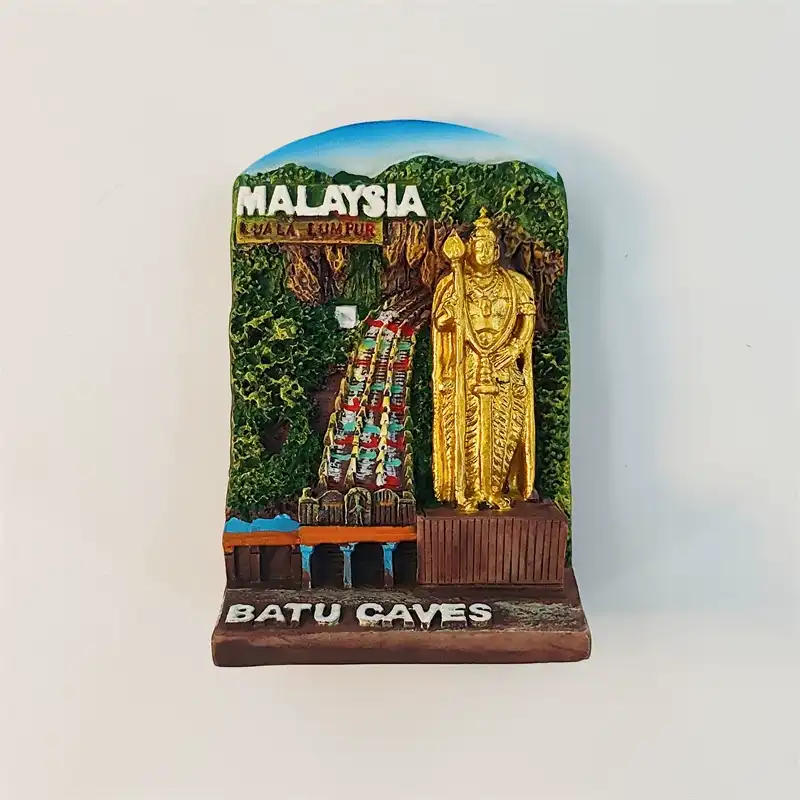 Front view of Malaysia Batu Caves fridge magnet with golden Murugan statue and rainbow stairs