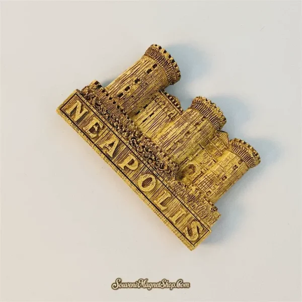 Angled view of a Naples Castel Nuovo souvenir magnet showing hand-painted golden castle towers
