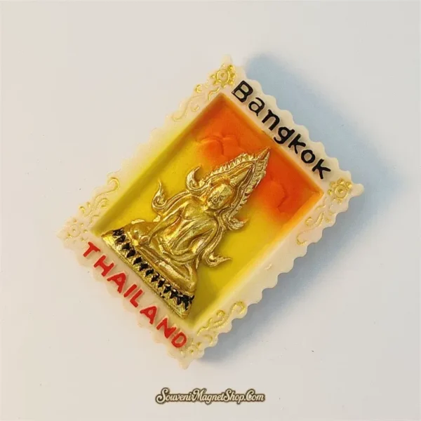 Thailand Bangkok souvenir magnet of golden Buddha on stamp-shaped frame shown at an angle