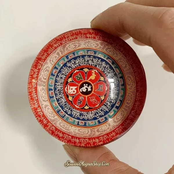 Tibetan Buddhist mantra glass magnet held in hand showing glossy domed lotus mandala detail