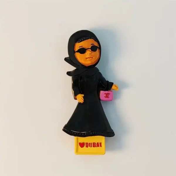 Front view of Dubai Emirati woman fridge magnet in black abaya with pink handbag and DUBAI base