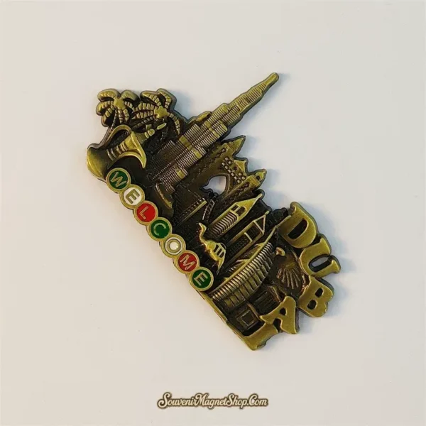 Angled view of bronze Dubai souvenir magnet showing skyline, palm trees and enamel WELCOME lettering