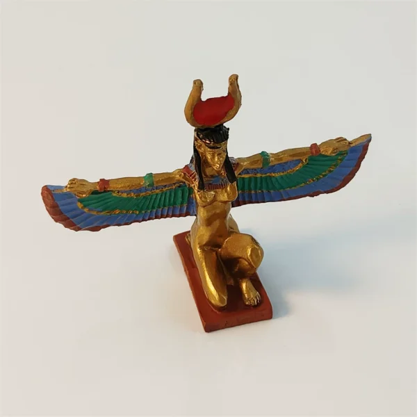 Gilded winged Isis souvenir figurine at an angle, green and blue painted feathers on red hieroglyph base