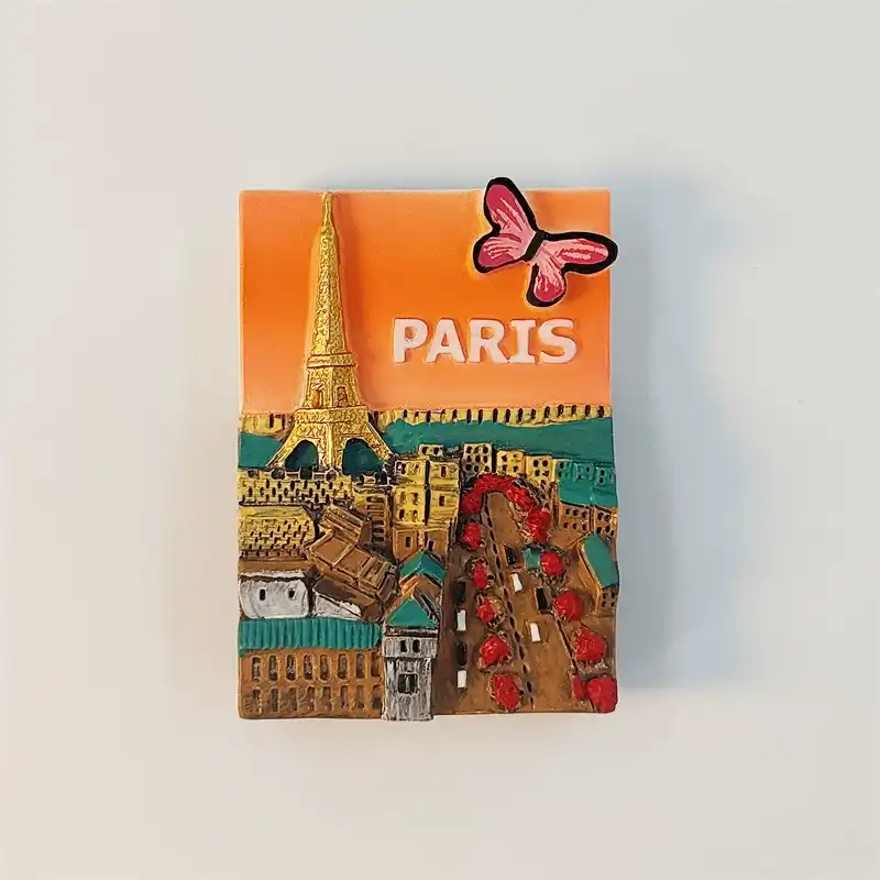 Front view of the 3D Paris fridge magnet with the golden Eiffel Tower, orange sky, PARIS sign and pink butterfly