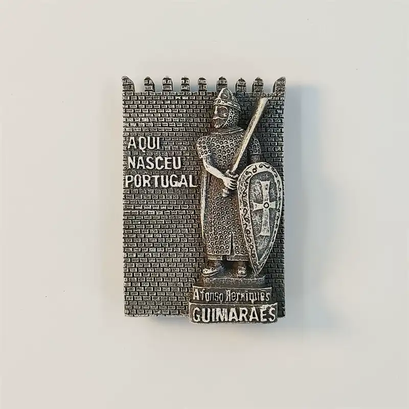 Front view of an antique-silver Guimaraes fridge magnet showing Afonso Henriques with sword and cross shield on a castle wall reading Aqui Nasceu Portugal