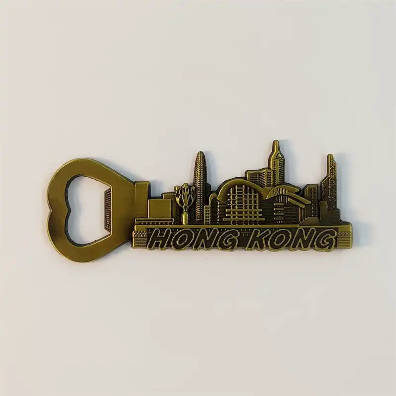 hong-kong-skyline-bottle-opener-magnet-front Front view of a bronze Hong Kong skyline fridge magnet bottle opener with HONG KONG lettering