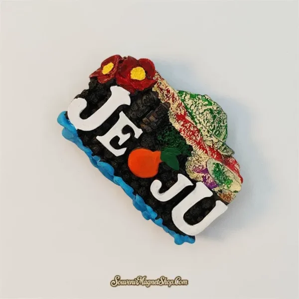 Angled view of the Jeju Island souvenir magnet showing the raised 3D lettering, tangerine and stone statues