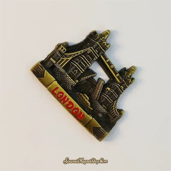 Angled view of a bronze London Tower Bridge souvenir magnet showing detailed towers and cables