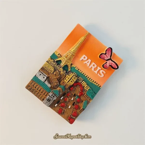 Angled view of the Paris souvenir magnet showing the raised 3D street scene and gilded Eiffel Tower