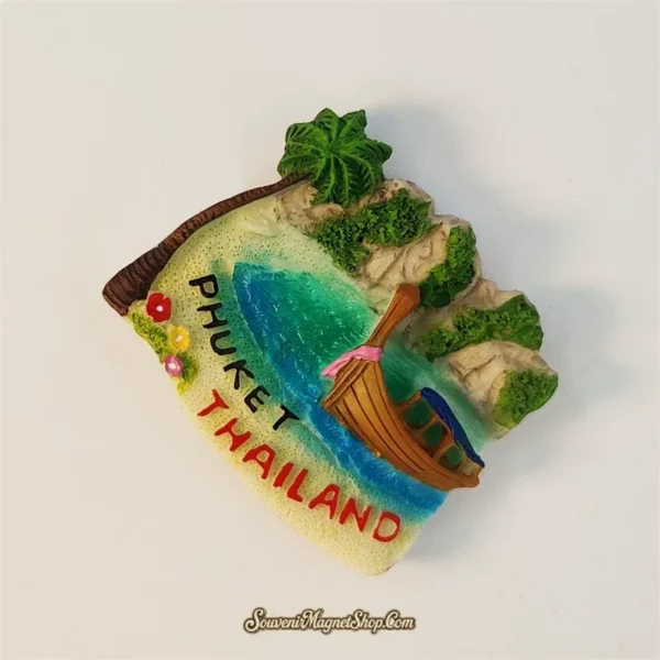 Angled view of hand-painted Phuket magnet showing longtail boat in a turquoise bay and Thailand lettering