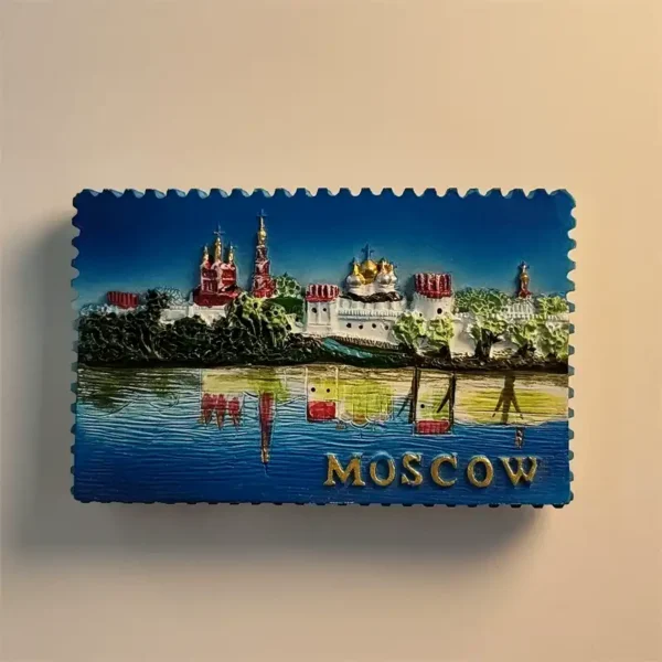 Front view of a stamp-shaped Moscow fridge magnet showing Novodevichy Convent reflected in water with gold MOSCOW lettering
