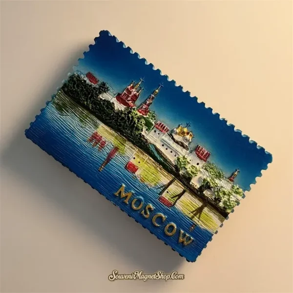 Angled view of the Moscow souvenir magnet showing the raised convent domes, green trees and blue stamp border