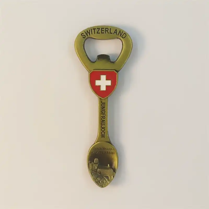 Front view of an antique bronze Switzerland Jungfraujoch bottle opener fridge magnet with Swiss cross