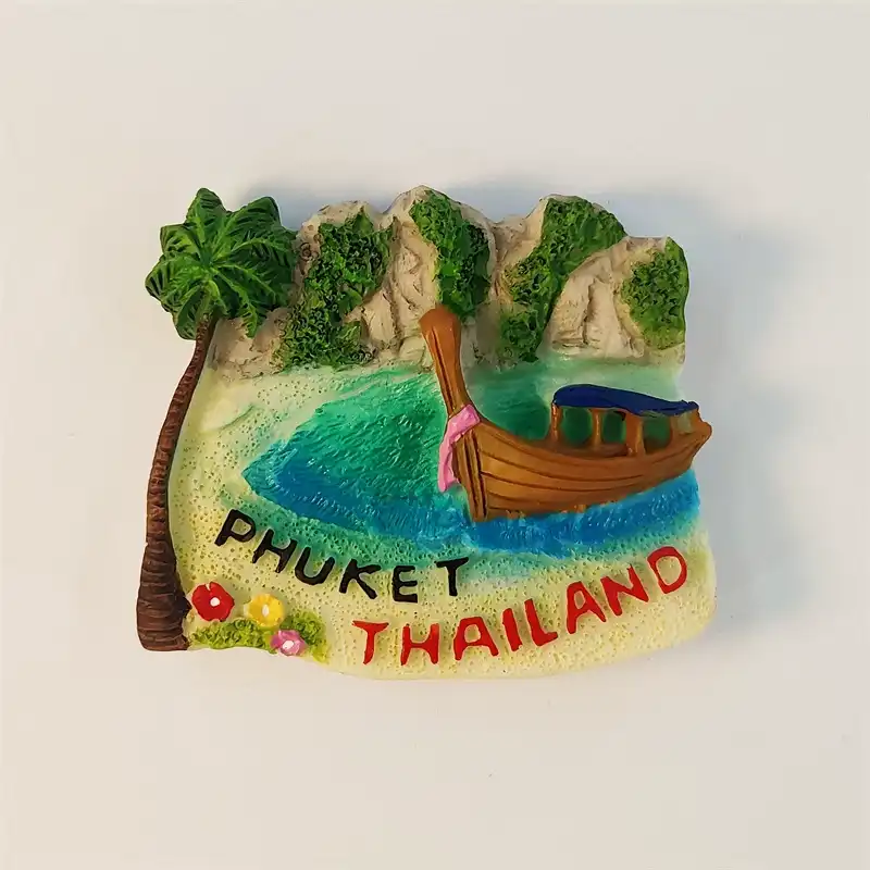 Front view of 3D hand-painted Phuket fridge magnet with a longtail boat, limestone cliffs and palm tree
