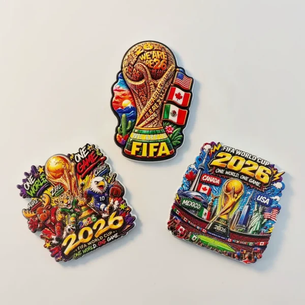 Three 2026 World Cup fridge magnets together showing the trophy, stadium skyline and mascot designs