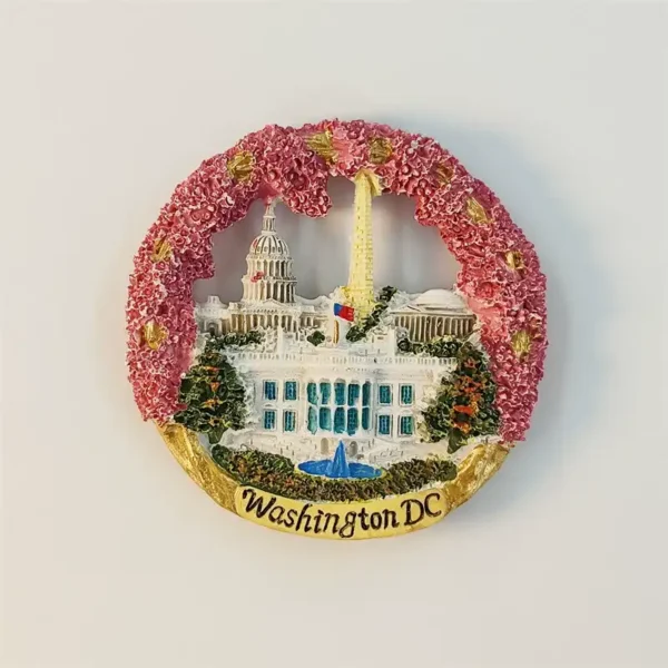 Front view of the round Washington DC fridge magnet framed by a pink cherry blossom wreath with the White House and Capitol