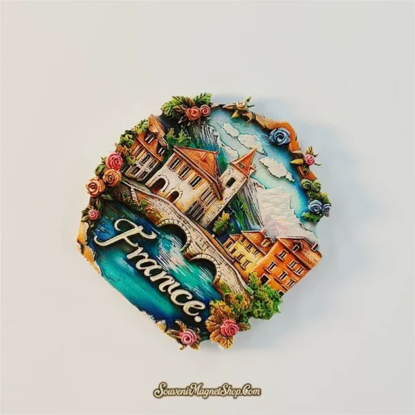 Angled view of France alpine village magnet showing raised 3D bridge, houses and mountain relief