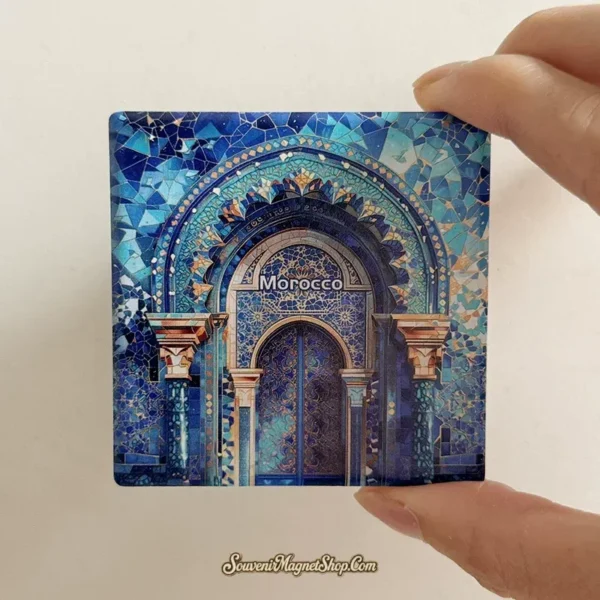 Morocco souvenir magnet held in hand, showing the blue mosaic arch ceramic design at true scale