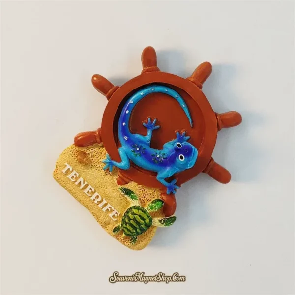 Angled view of Spain Tenerife souvenir magnet showing blue lizard, ship wheel, sand base, and turtle