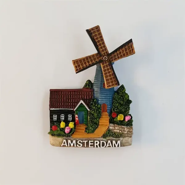 Amsterdam windmill fridge magnet with brown lattice sails, a blue tower, red-roofed cottage, colorful tulips and a golden path.
