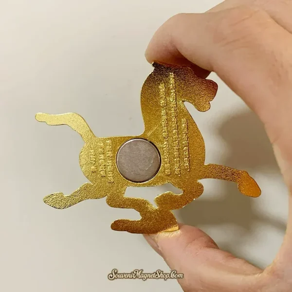 Back of the Gansu Flying Horse fridge magnet showing a round magnet disc and gold-colored reverse.