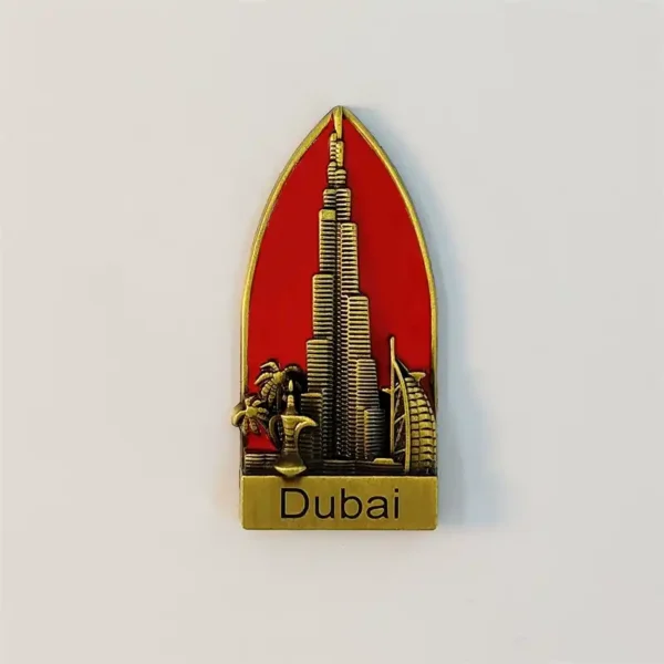 Dubai metal fridge magnet with raised Burj Khalifa and Burj Al Arab landmarks on a red sail-shaped background.