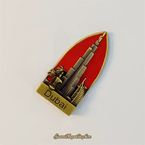 Angled Dubai fridge magnet showing the gold-tone Burj Khalifa, Burj Al Arab, palm details, and Dubai nameplate.