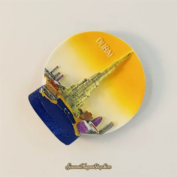 Dubai Burj Khalifa magnet tilted clockwise, showing the raised tower, yellow-to-cream sky disc and blue foreground.