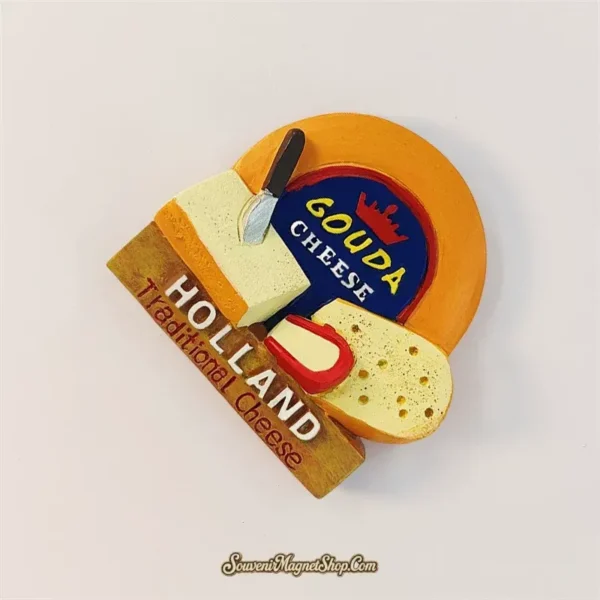 Holland Gouda cheese fridge magnet angled right, showing the cheese wheel, wedges, knife, and raised lettering.
