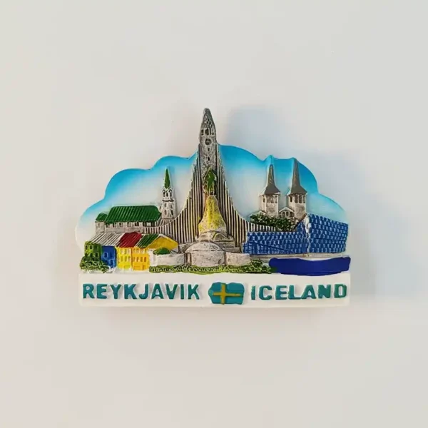 Front view of the Reykjavik Iceland skyline fridge magnet showing Hallgrímskirkja's spire, colorful harbor houses, and the blue Harpa hall above a Reykjavik–Iceland flag banner.