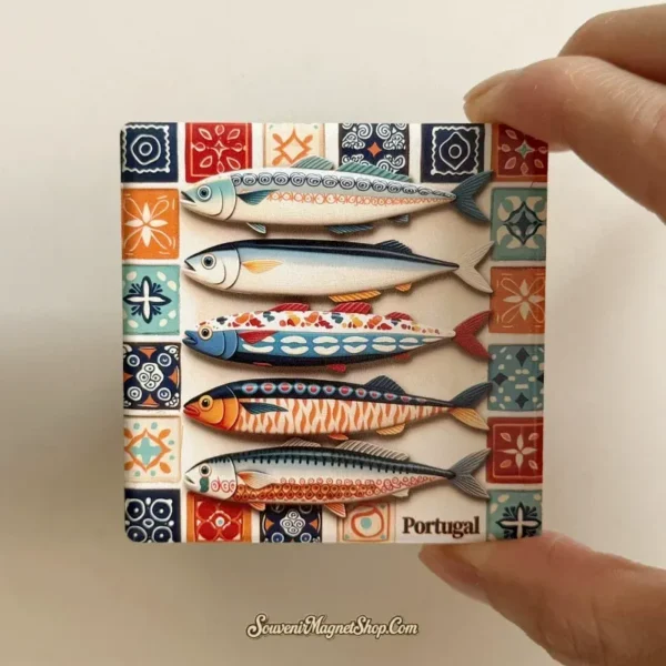 Hand holding a square Portugal fish tile fridge magnet, showing its patterned border and thin edge.