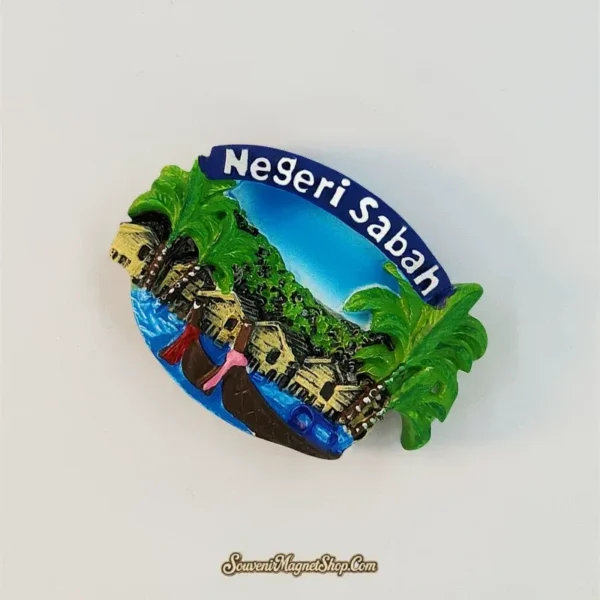 Angled view of the Sabah water village fridge magnet showing layered palms, stilt houses and boats beneath Negeri Sabah text.