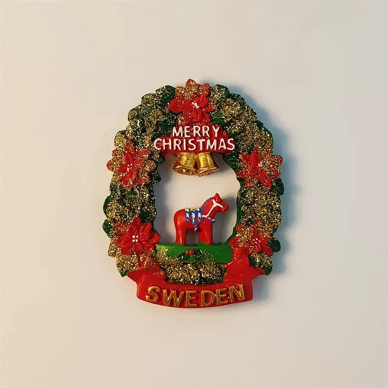 sweden-dala-horse-christmas-wreath-fridge-magnet-front Sweden Dala horse Christmas wreath fridge magnet with red flowers, gold bells and Merry Christmas lettering.