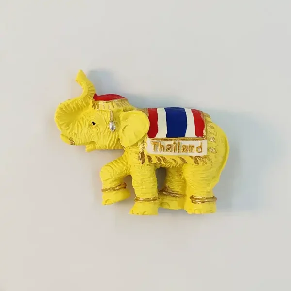 Thailand golden elephant fridge magnet with raised trunk, flag-colored saddlecloth and embossed Thailand plaque.