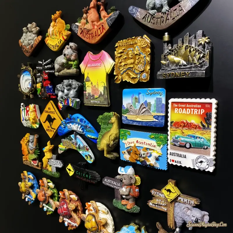 Australian souvenir fridge magnets featuring koalas, kangaroos, Sydney landmarks, boomerang shapes and road signs displayed on a black background.