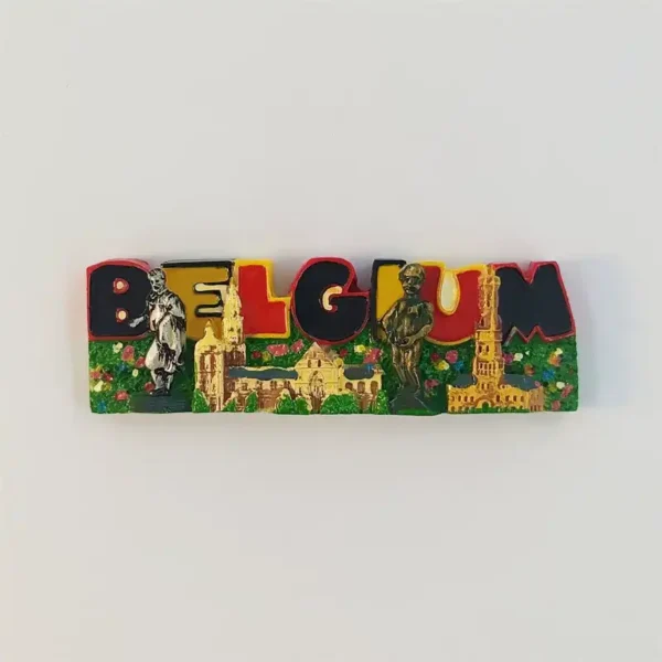Belgium letters fridge magnet with black, yellow and red lettering, golden buildings, two sculpted figures and a green flower-dotted base.