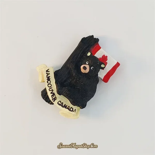 Vancouver black bear fridge magnet tilted clockwise, showing the tree-hugging pose, maple leaf flag and cream scroll.